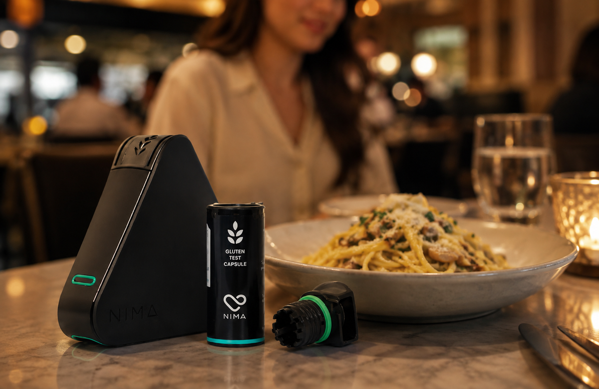 Diner using a portable gluten sensor to test restaurant food for gluten before the first bite